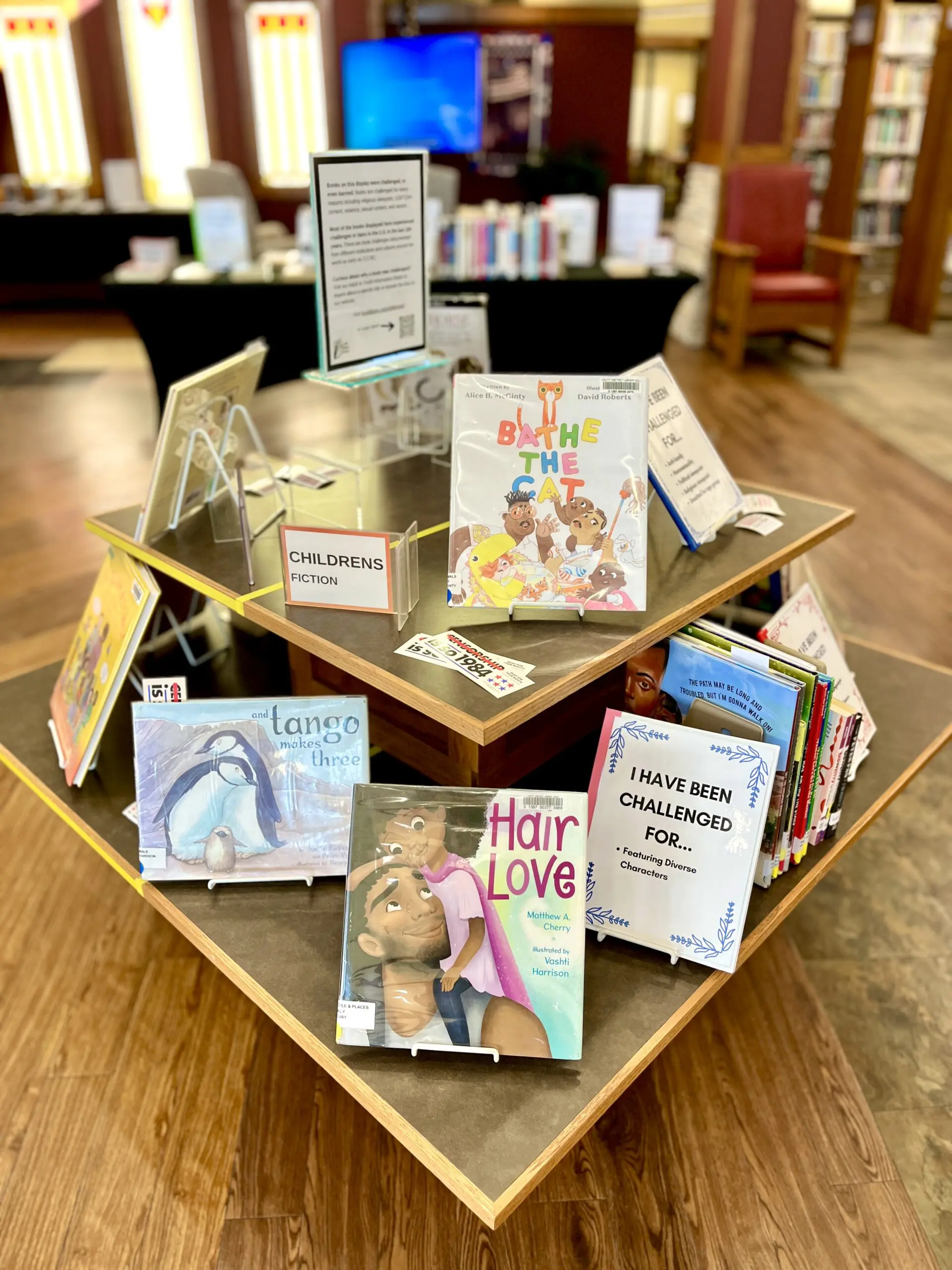 photo of picture book display featuring popularly challenged picture books like "Hair Love", "Tango Makes Three", and "Bathe The Cat"