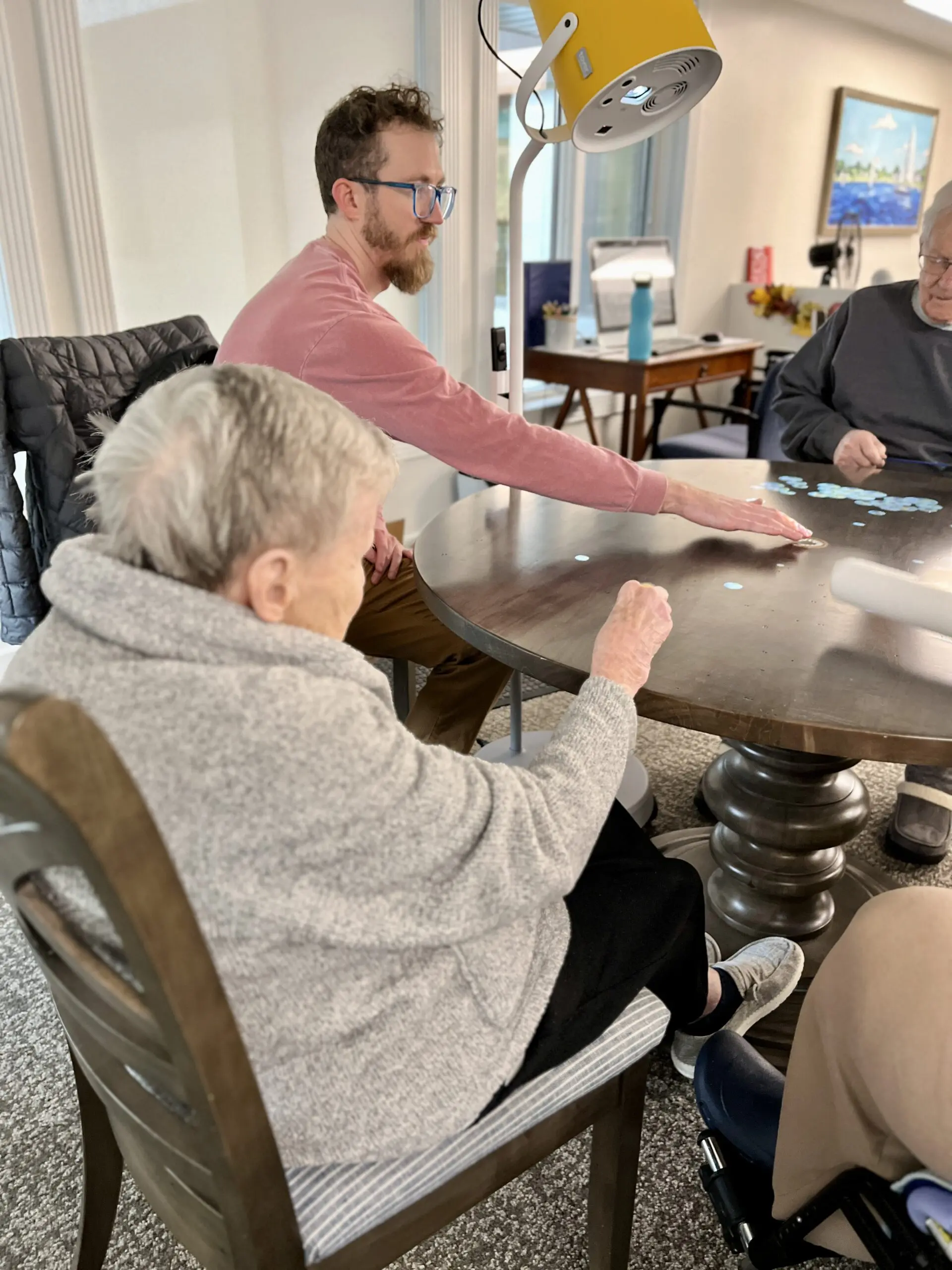 Christian Haven Pixie 1 Image of a young man and an elderly woman interacting with a projection on a table