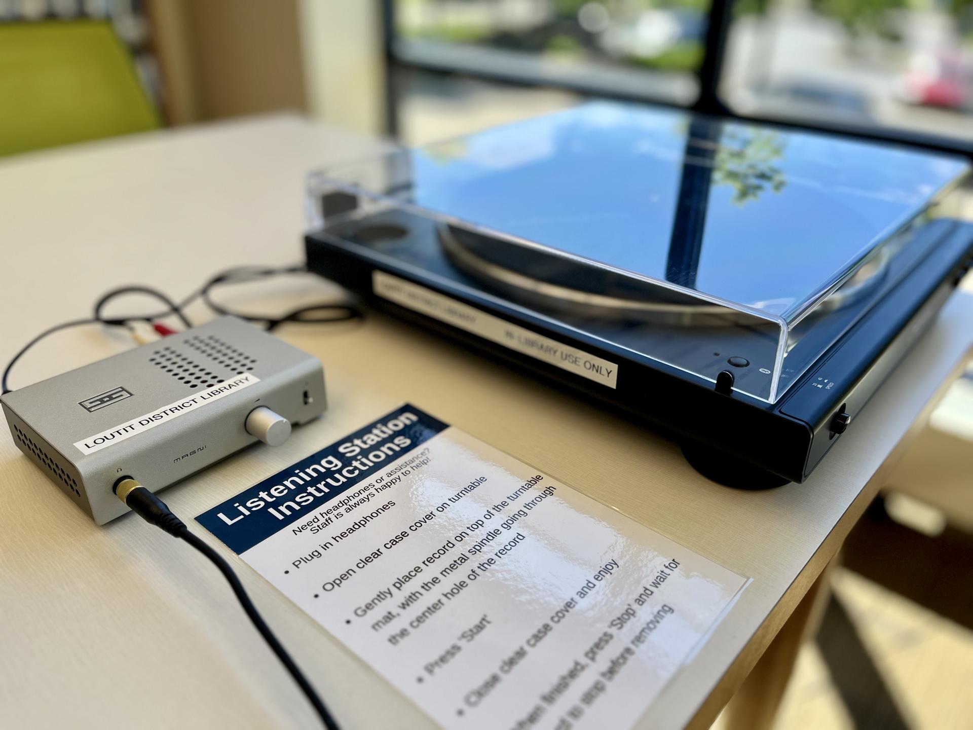 Image of a vinyl listening station containing a record player, headphone amp, and instructions on how to use the player.