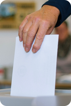 millage ballot close up image of a hand putting a ballot into a ballot box