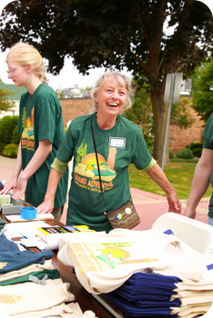 millage outreach image of older woman running a booksale with a warm smile on her face